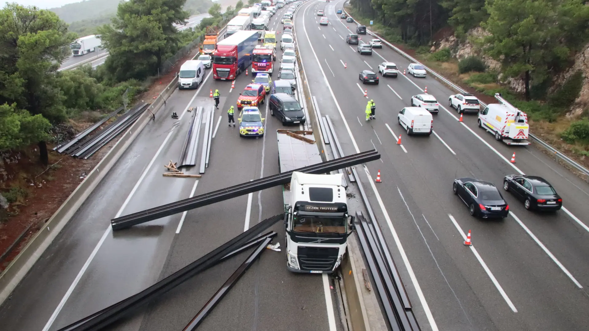 El accidente de un camión corta la AP-7 y deja la vía colapsada con su carga de vigas de hierro
