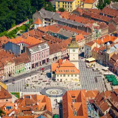 High Angle view of the town of Brasov in Romania centred on the Town Hall building. People can be seen goin about their activities in the town square.