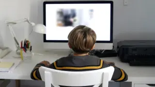 Foto de archivo de un niño con un ordenador.