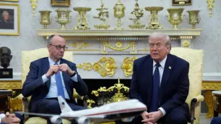 Donald Trump y Friedrich Merz en una reunión en la Casa Blanca, con un modelo de avión en primer plano.
