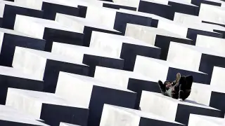 <strong>Primavera alemana. </strong>Una joven disfruta del sol en uno de los bloques del monumento en memoria de las víctimas del Holocausto en Berlín.