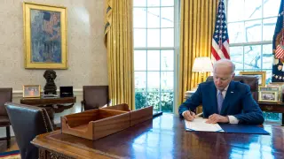 Joe Biden firma un ley en el despacho oval de la Casa Blanca.