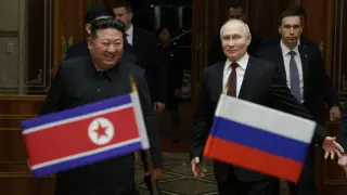 En esta fotografía de grupo distribuida por la agencia estatal rusa Sputnik, el líder de Corea del Norte, Kim Jong Un (izq.), camina junto al presidente ruso, Vladímir Putin, durante una ceremonia de bienvenida a la llegada de Putin a Pyongyang, a primera hora del 19 de junio de 2024.