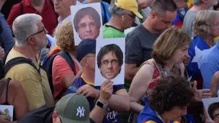 Varias personas con fotos con la cara de Puigdemont.