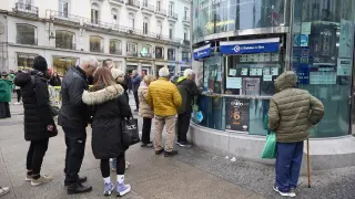 Varias personas hacen cola ante una administración de Lotería de Madrid.