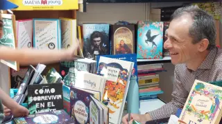 Pedro Duque firma ejemplares de su libro en la Feria del Libro de Madrid.