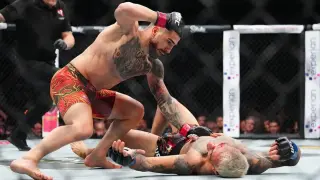 Ilia Topuria asesta varios puñetazos a Charles Oliveira, ya KO en el suelo.