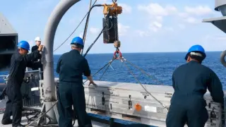 Marineros cargan un misil RIM-7 NATO Sea Sparrow en un lanzador en la cubierta de misiles del USS Iwo Jima.