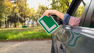 Un coche de un autoescuela con la L que acredita el aprobado en el examen.