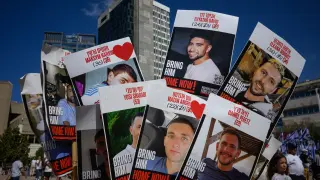 Carteles de los secuestrados liberados este lunes en la plaza de los rehenes de Tel Aviv.