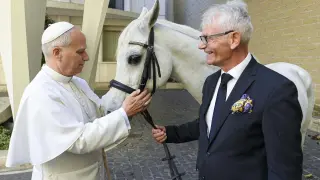 VATICAN CITY (Vatican City State (Holy See)), 15/10/2025.- A handout picture provided by the Vatican Media shows Pope Leo XIV (L) receiving a white horse as a gift, on the sidelines of the general audience, in Vatican City, 15 October 2025. The horse name is Proton and he comes from a stable in Kolobrzeg-Budzistowo, Poland. (Papa, Polonia) EFE/EPA/VATICAN MEDIA HANDOUT HANDOUT EDITORIAL USE ONLY/NO SALES