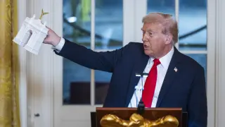 El presidente de Estados Unidos, Donald Trump sostiene una maqueta del Arco del Triunfo.