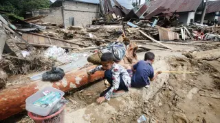 Dos niños juegan junto a casas destruidas por las inundaciones en la isla de Sumatra, en Indonesia.