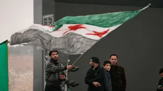 A man waves a Syrian flag ahead of a parade by the new Syrian army marking the first anniversary of the ousting of the Bashar Assad regime in Damascus, Syria, Monday, Dec. 8, 2025. (AP Photo/Hussein Malla)Associate Press/ LaPresseOnly Italy and Spain