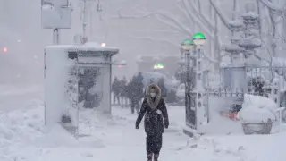 A pedestrian walks along 42nd Street near Bryant Park during a snow storm, Monday, Feb. 23, 2026, in New York. (AP Photo/Seth Wenig)