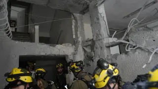 Israel's rescue teams inspect a site struck by an Iranian missile in Bnei Brak, Wednesday, April 1, 2026. (AP Photo/Oded Balilty)