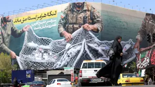 FOTODELDIA Teherán, 05/04/2026.- Una mujer pasa junto a una valla con el mensaje "El estrecho de Ormuz permanecerá cerrado" en la plaza Enghelb de Teherán, 5 de abril de 2026. EFE/ABEDIN TAHERKENAREH