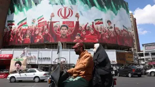 TEHRAN (IRAN(Islamic Republic Of)), 08/04/2026.- People drive past a political billboard in the colors of Irans national flag at Valiasr Square in Tehran, Iran, 08 April 2026. Iran and the USA agreed to a two-week truce to halt military operations and keep the Strait of Hormuz open for oil and gas shipments, with formal peace talks set to begin in Islamabad on 10 April 2026. (Teherán) EFE/EPA/ABEDIN TAHERKENAREH