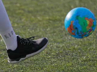Un activista de Greenpeace golpea una pelota con forma de globo terr&aacute;queo, durante una marcha contra el cambio clim&aacute;tico, en Mosc&uacute; (Rusia).