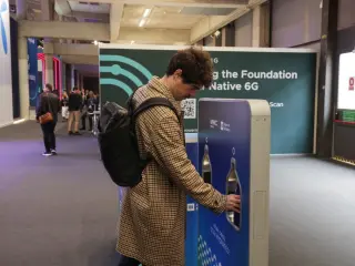 Un asistente del MWC usa una de las fuentes con agua del grifo de proximidad de Aig&uuml;es de Barcelona.