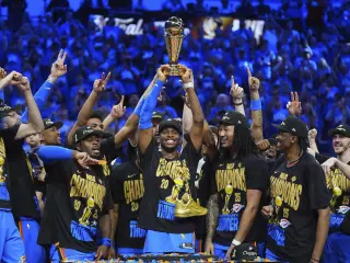 Oklahoma City Thunder guard Shai Gilgeous-Alexander, center, holds up the MVP trophy as he celebrates with his team after they won the NBA basketball championship with a Game 7 victory against the Indiana Pacers Sunday, June 22, 2025, in Oklahoma City. (AP Photo/Julio Cortez) Associated Press/LaPresse