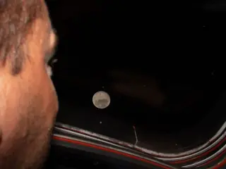 El comandante de Artemis II y astronauta de la NASA, Reid Wiseman, observa la Luna a través de una de las ventanas de la cabina principal de la nave espacial Orion.