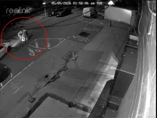 Imagen de un video de vigilancia en el que se ve a tres personas bajando a una alcantarilla en una calle de Nueva York.