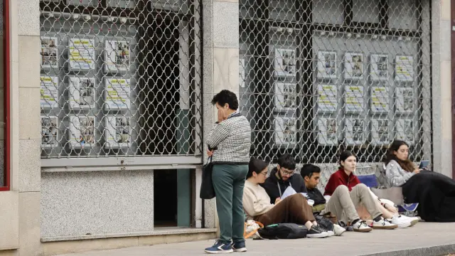 Varios jóvenes esperan a las puertas de una inmobiliaria en Santiago.