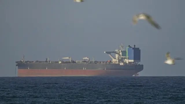 Un barco espera para cruzar el estrecho de Ormuz tras el alto el fuego temporal de dos semanas entre Estados Unidos e Irán.