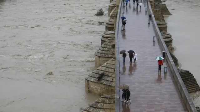 Varias personas pasean por el puente romano, este domingo en Córdoba.