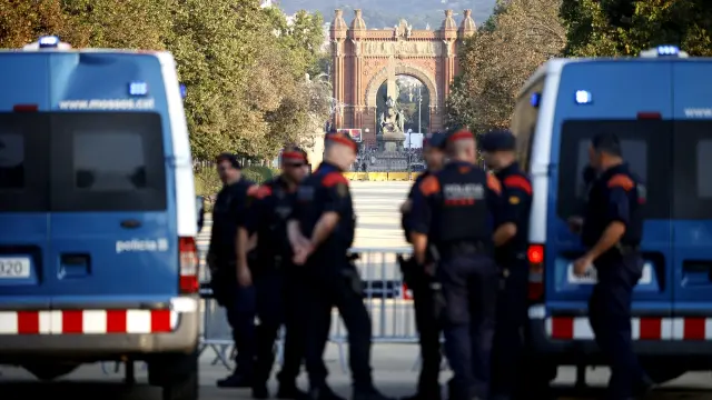 Agentes de los Mossos d' Esquadra y varias personas en las inmediaciones del Parlament de Cataluña.