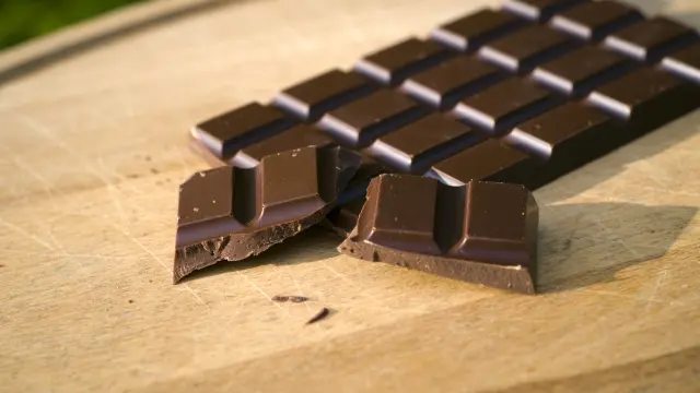 Barra de chocolate sobre una tabla de madera.