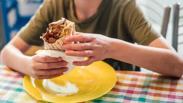 Un joven comiendo un kebab, en una imagen de archivo.