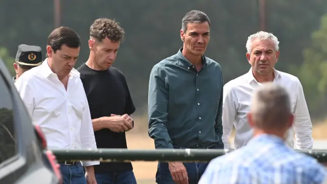 El presidente del Gobierno, Pedro Sánchez (c), junto al presidente de la Junta de Castilla y León, Alfonso Fernández Mañueco (i), y el alcalde de la localidad, Mario Rivas, este domingo a su llegada a Caboalles (León), para seguir la última hora del incendio de Orallo (León). EFE/ J.Casares