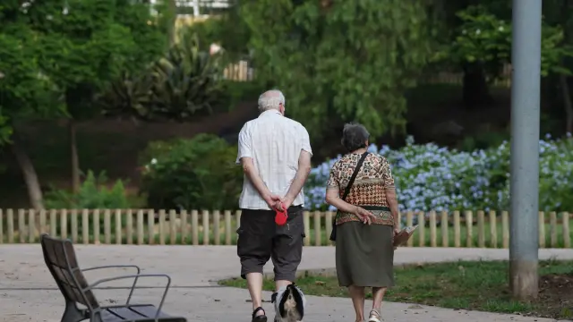 Una pareja de personas mayores pasea al perro en Barcelona.