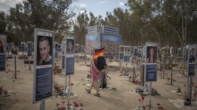 Una mujer con una bandera alemana pasea por el lugar del festival Nova, donde tuvo lugar la matanza de Hamás.