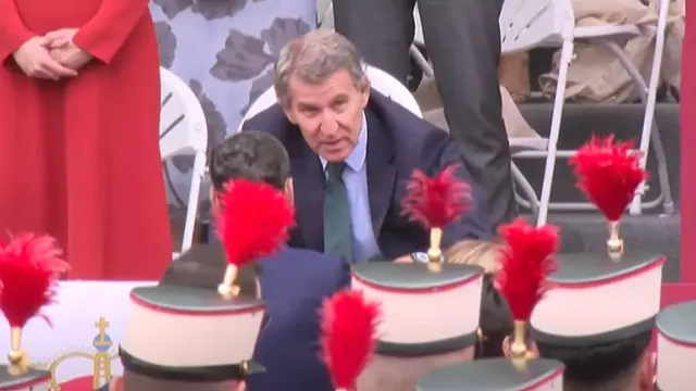 El líder del PP, Alberto Núñez Feijóo, habla con Juan Manuel Moreno Bonilla antes del desfile del 12 de octubre.