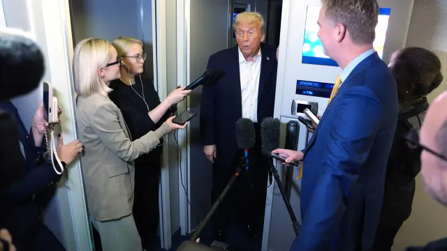 El presidente Donald Trump habla con los periodistas a bordo del Air Force One durante una parada para repostar en la base aérea de Mildenhall, cerca de Bury St. Edmunds, en el este de Inglaterra, en la madrugada del martes 14 de octubre de 2025, mientras regresa a Washington.