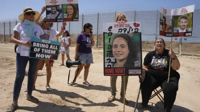 Hana Cohen, en el centro a la derecha, sostiene un cartel con la foto de su sobrina, Inbar Haiman, quien se encuentra secuestrada por Hamás en la Franja de Gaza durante una protesta que exige la liberación de todos los rehenes. Ella se encuentra junto a otros simpatizantes junto a la valla fronteriza entre Israel y Gaza, en el sur de Israel, el jueves 28 de agosto de 2025.
