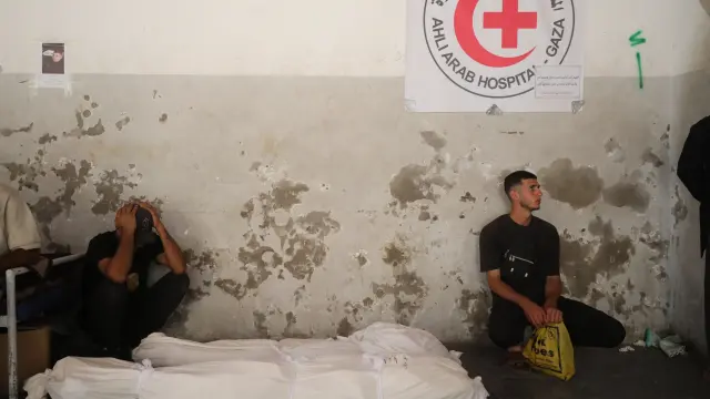Dos personas lloran ante los cuerpos de varios palestinos muertos por fuego israelí.