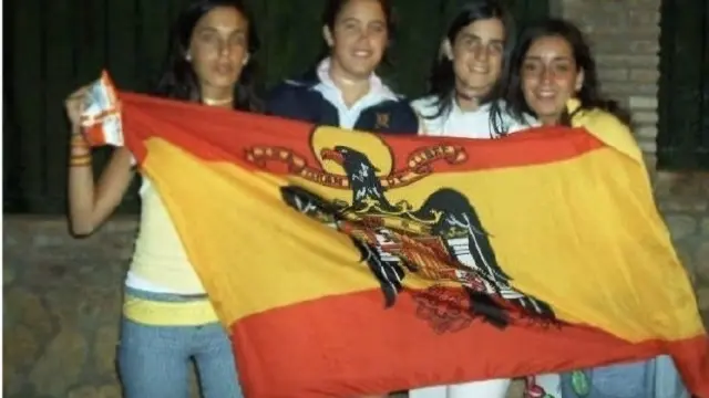 Chicas jóvenes presumen de la bandera de la Dictadura de Franco.