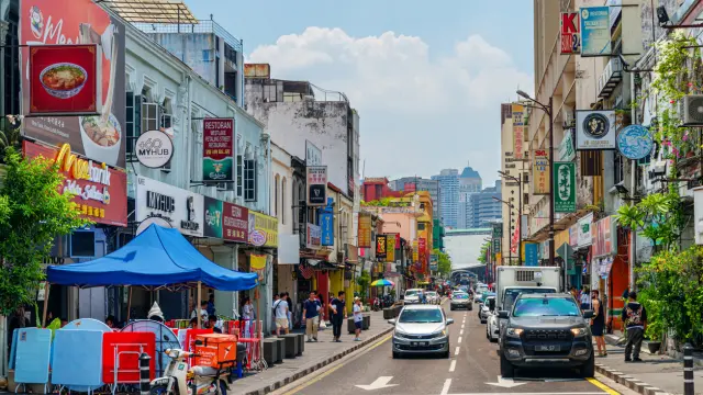 Kuala Lumpur, Malaysia - 23 July, 2023: Scenic facades of old buildings at Chinatown. Day traffic on Jalan Sultan Street. Colorful cityscape. Kuala Lumpur is a popular tourist destination of Asia.
