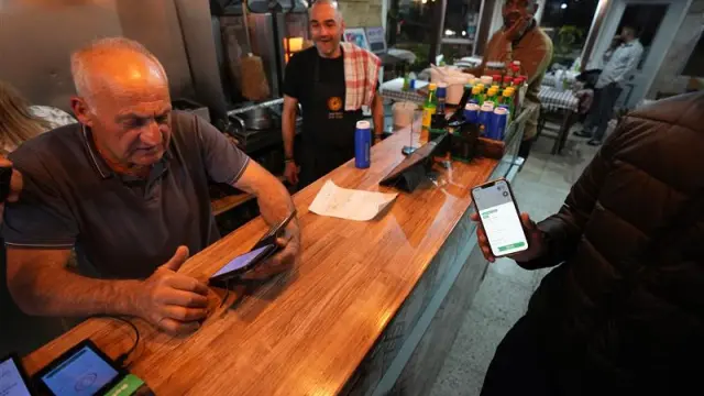 Chipriotas, leyendo un SMS de alerta de prueba enviado por el Gobierno tras el ataque a una base en la isla.