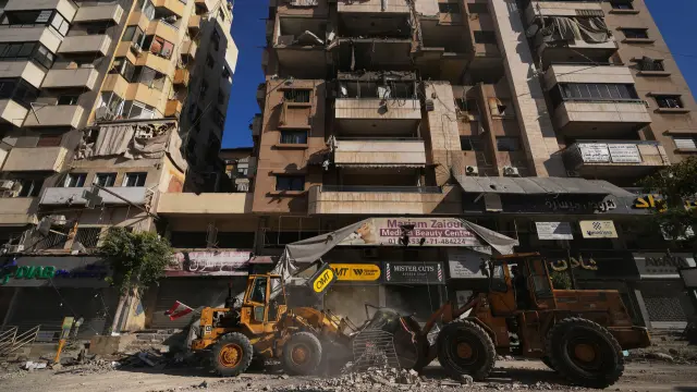 Bulldozers clear debris from a building damaged in an Israeli airstrike in Dahiyeh, Beirut's southern suburbs, Lebanon, Tuesday, March 17, 2026. (AP Photo/Hassan Ammar)