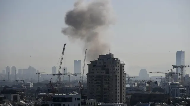 Una densa columna de humo se eleva tras un ataque con misiles iraníes en Tel Aviv, el martes 24 de marzo de 2026.