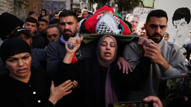 Una madre lleva consigo el cuerpo de su hijo de 15 años, quien, según el Ministerio de Salud palestino, murió en una incursión del ejército israelí en Cisjordania.