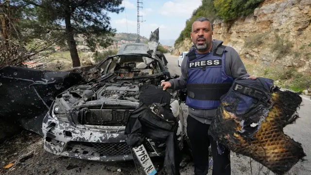 Un periodista transporta equipo de seguridad quemado tras un ataque aéreo israelí contra un automóvil que acabó con la vida del corresponsal de la cadena de televisión Al Manar de Hezbolá, Ali Shaib, la reportera de la cadena Al Mayadeen, Fatima Fatouni, radicada en Beirut, y su hermano, el cámara Mohamed Fatouni, al sur del Líbano.
