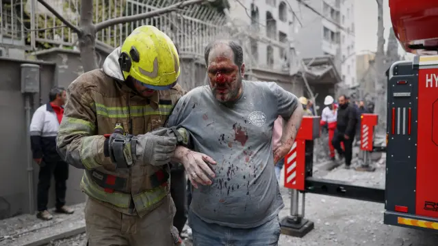 Un rescatista atiende a un hombre herido tras un ataque aéreo de Israel contra un edificio residencial en Teherán, Irán, este 28 de marzo.