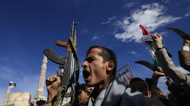 Partidarios de los hutíes gritan consignas y alzan sus armas durante una manifestación en solidaridad con Irán en Saná, Yemen.