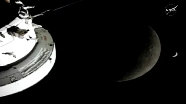 In this image from video provided by NASA, the Orion Spacecraft, the Earth and the Moon are seen from a camera as the Artemis II crew and spacecraft travel farther into Space, Monday, April 6, 2026. (NASA via AP)